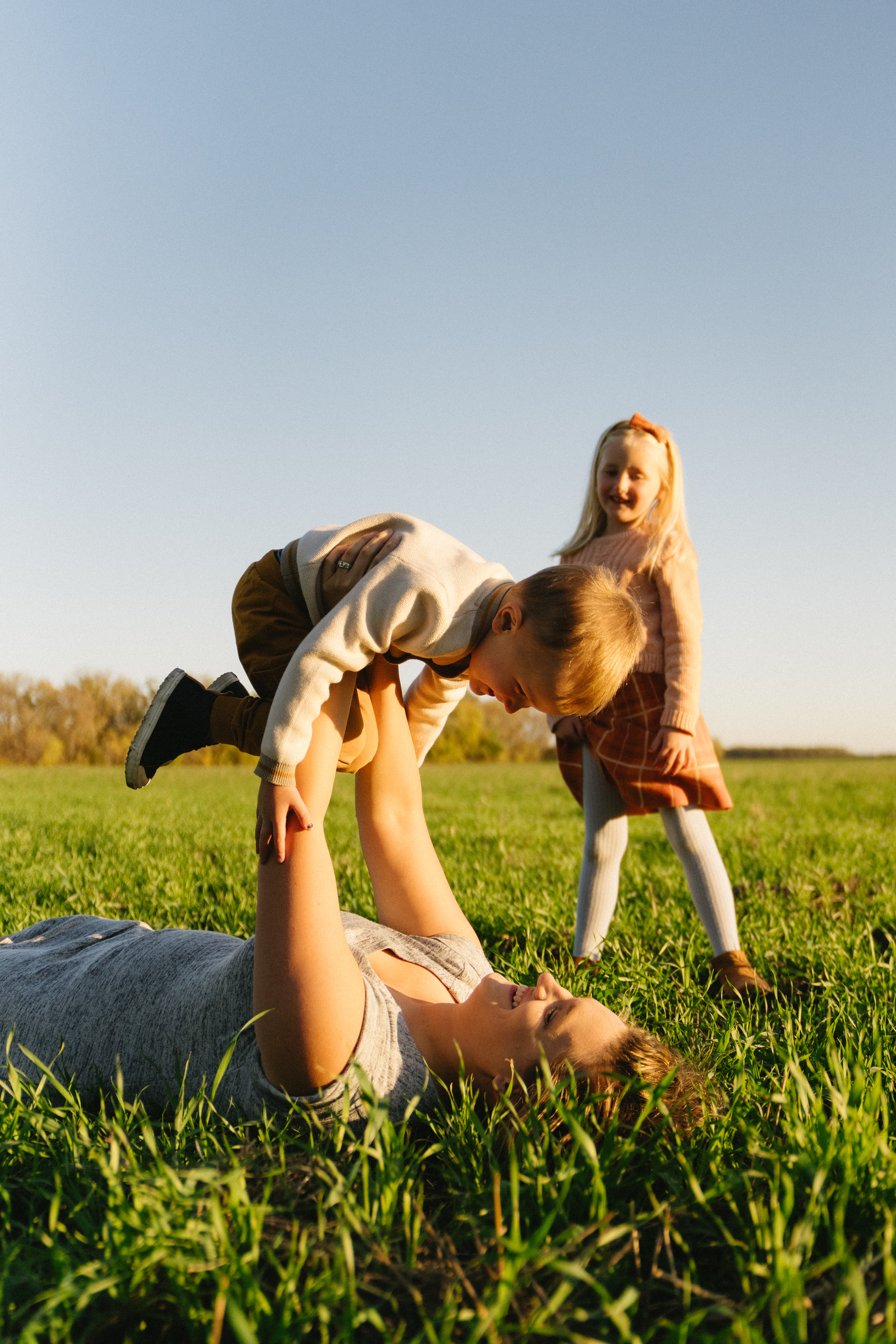 Natalia with her kids in a field at golden hour
